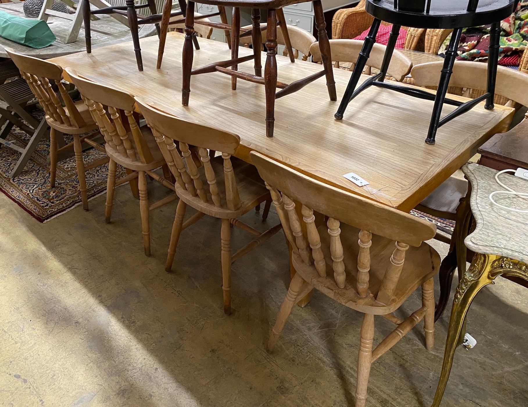 A modern bleached wood kitchen table, length 210cm, height 85cm with a set of eight beech kitchen chairs